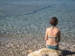 Claire sitting at Mikros Mourtias Claire contemplates the water with a wonderful back