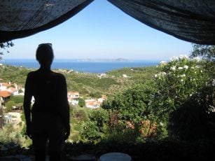 A woman stands practicing Alexander Technique looking out over a beautiful view